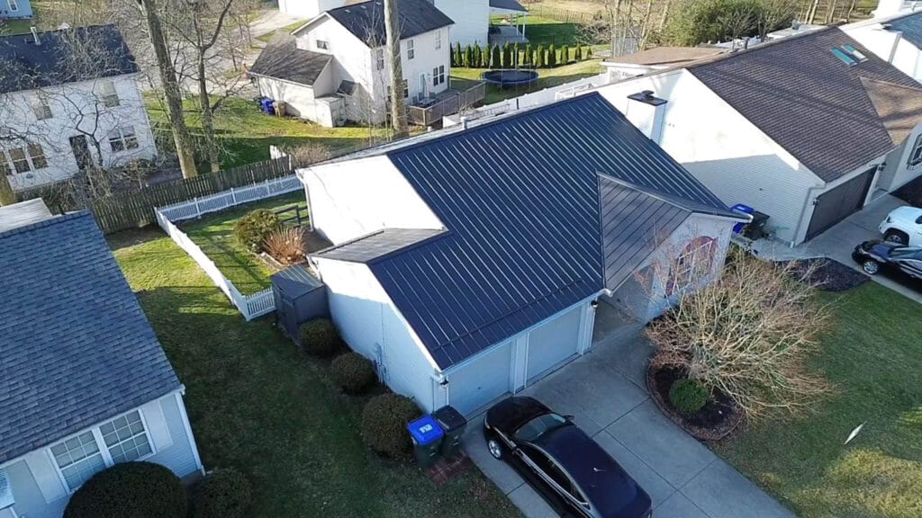 Professional metal roofing installation crew working on standing seam roof in Akron Ohio