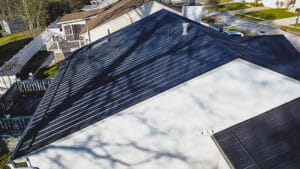 Professional metal roofers installing standing seam metal roofing system on Akron home