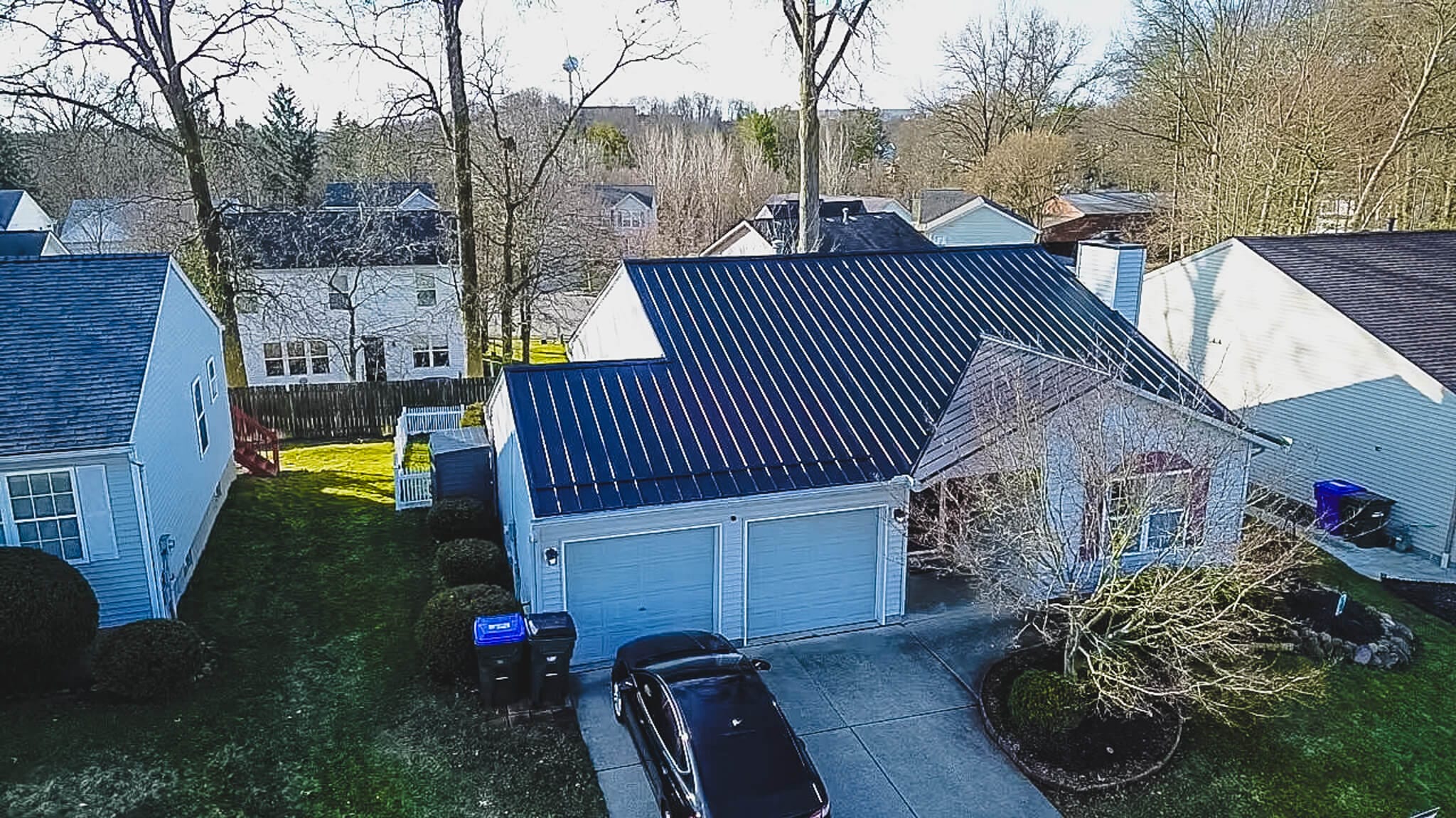 Skilled metal roofing specialists installing reflective metal roof system on Akron home
