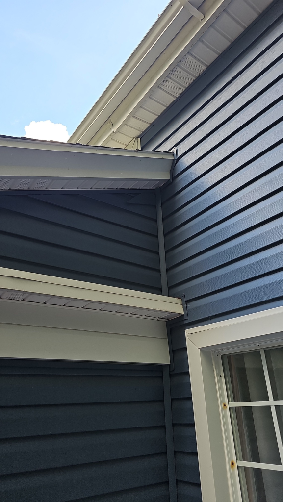 Crew finishing new vinyl siding on Akron home near 44313 for Eagle Eye Roofing